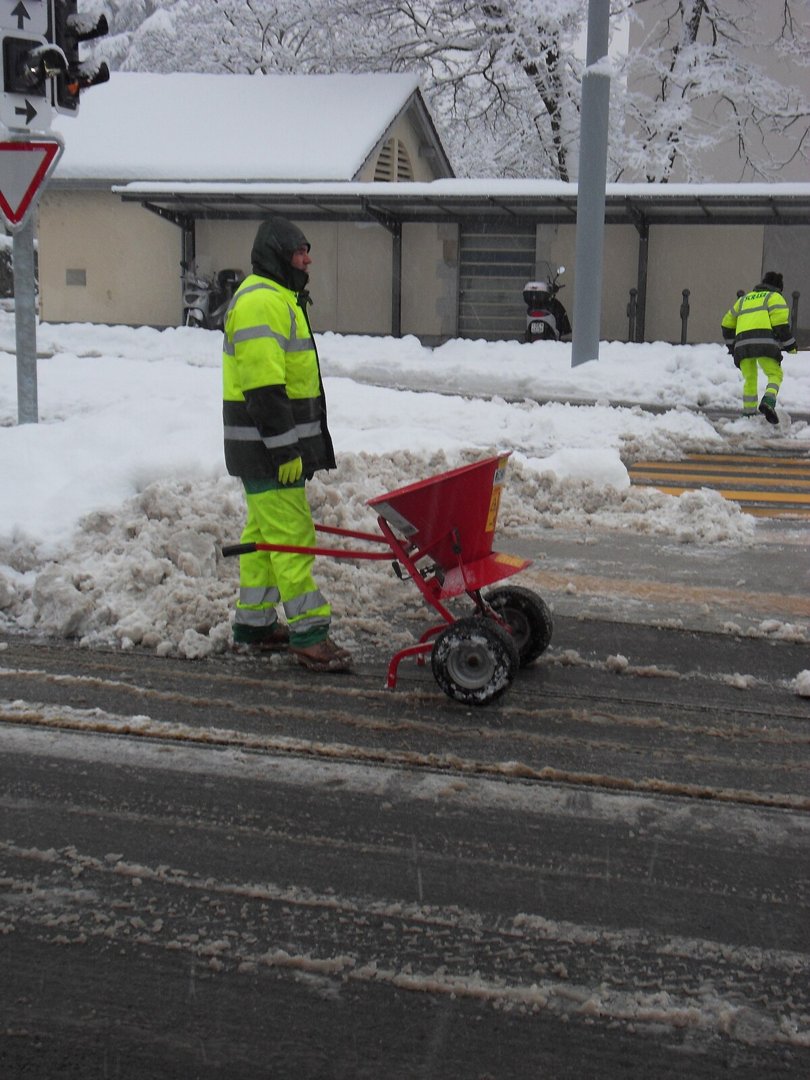 Man_salting_the_bus_stop_in_Onex.JPG